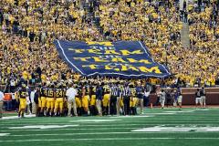 Giant crowd pass along banner for Michigan
